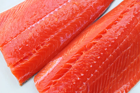 Wild-caught sockeye salmon fillets on a white background