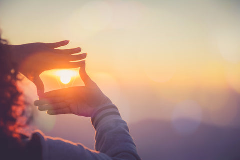 The woman making frame round the sun with her hands in sunrise,Future planning idea concept.