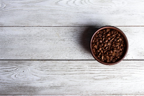 Coffee Beans in Bowl on Wood Backdrop