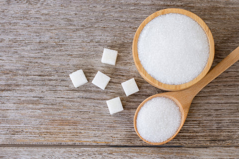 Table sugar on a spoon on a wooden table