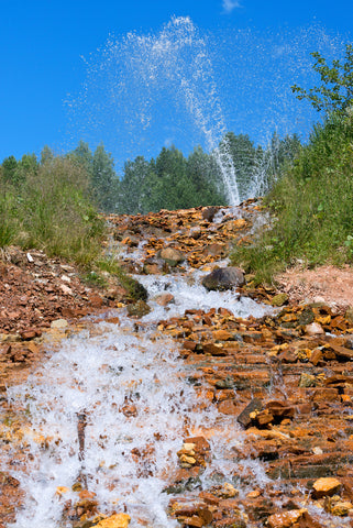 Jets of artesian water gushing from the ground and flowing down cascades down.