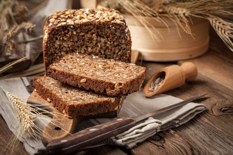 Whole Grain rye bread with seeds on a wooden board.