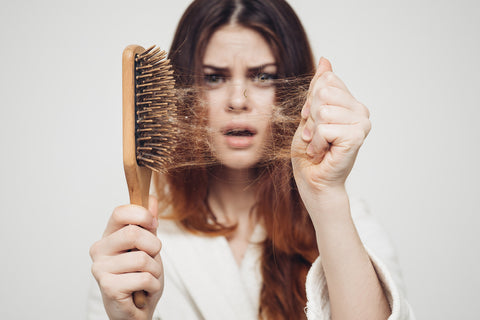 girl with a comb and problem hair on white background