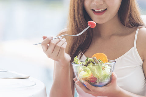 Healthy food healthy lifestyle with young happy woman eating green fresh ingredients organic salad. Vegan girl holding salad bowl with smiling face eating healthy diet food.