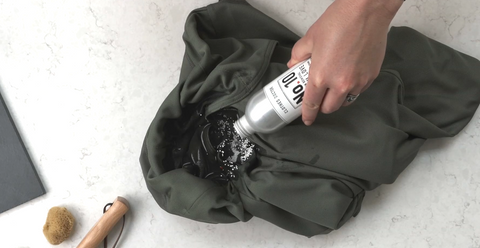 Stain removal powder being applied to damp stained area of clothes
