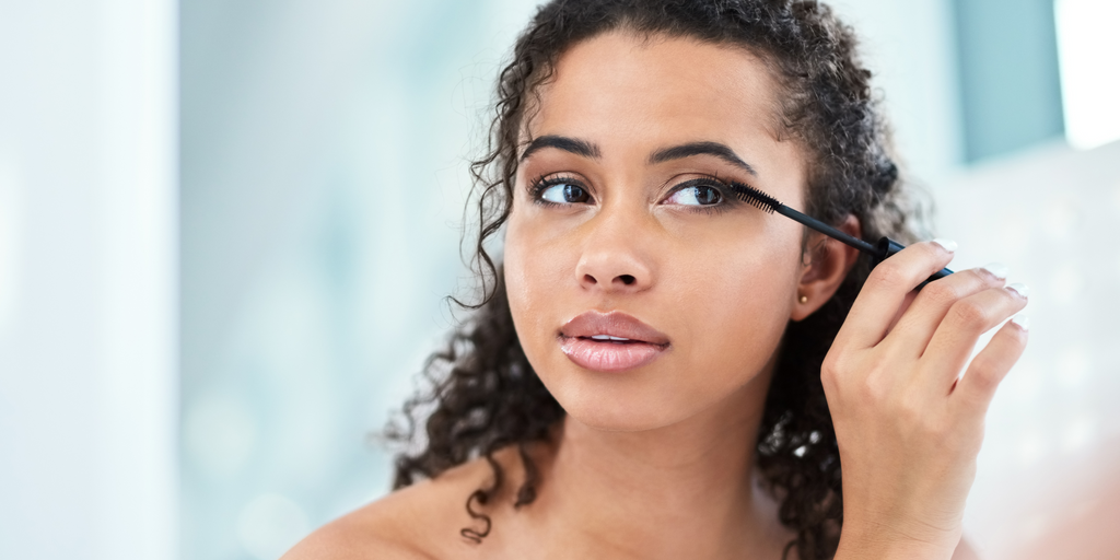 woman brushing her lashes 