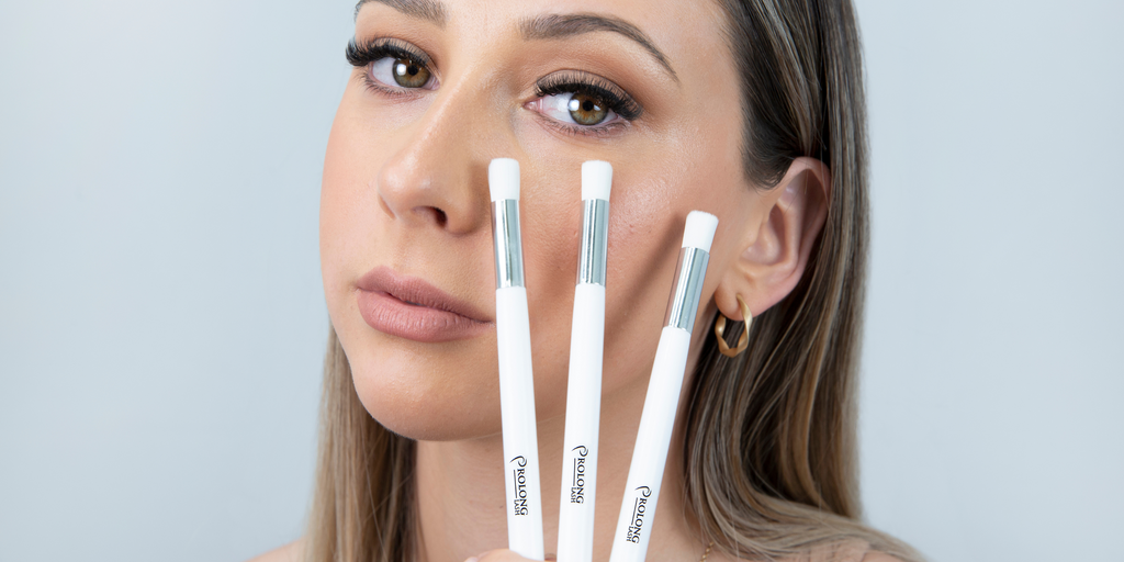 Woman cleaning her lashes with Prolong Lash Cleansing Brush