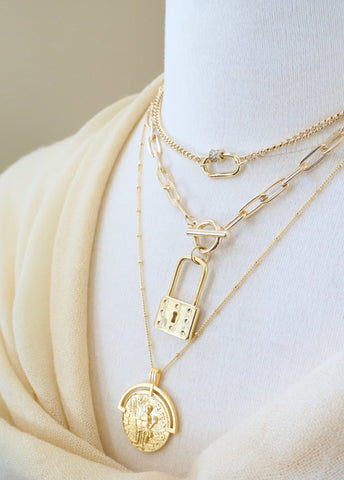 Layered Gold Necklace with short carabiner necklace, large padlock toggle necklace and long coin necklace