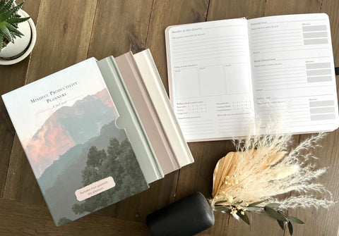 Mindful Productivity Planners box set and an open planner on a wooden table