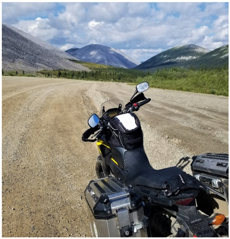 Motorcycle on a dirt road in front of moutains