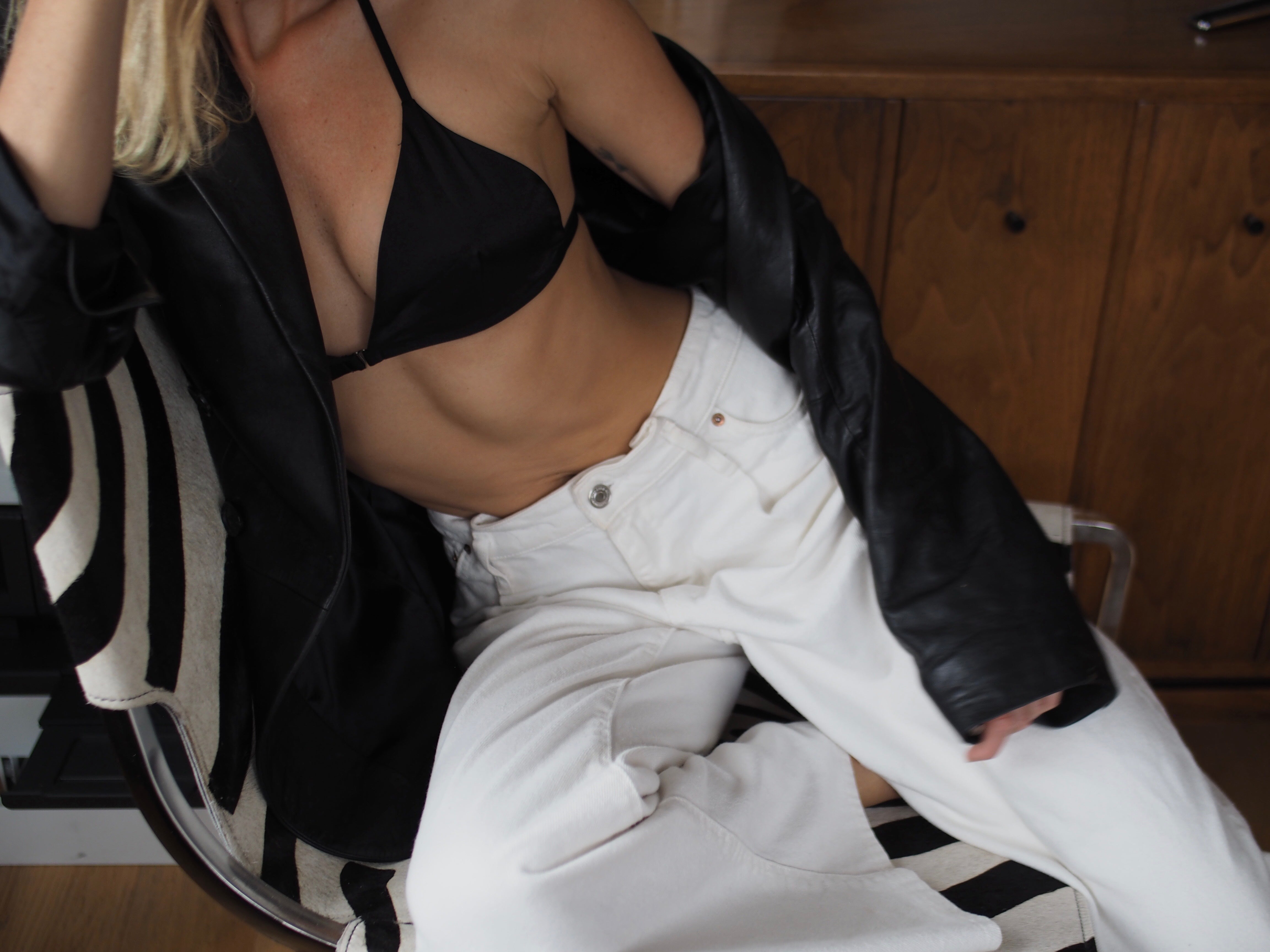 Elly McGaw wears our Muir triangle silk bralette in black with white jeans
