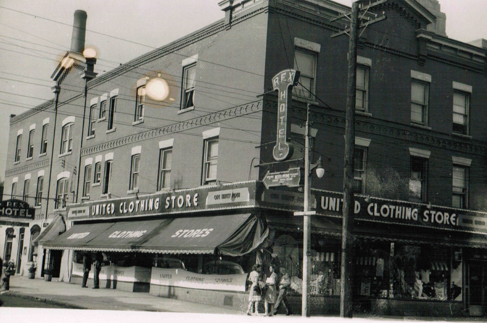 A picture of The Rex building in the 1950's, when it changed from being just clothing store to offering a beverage room and monthly accommodations.  