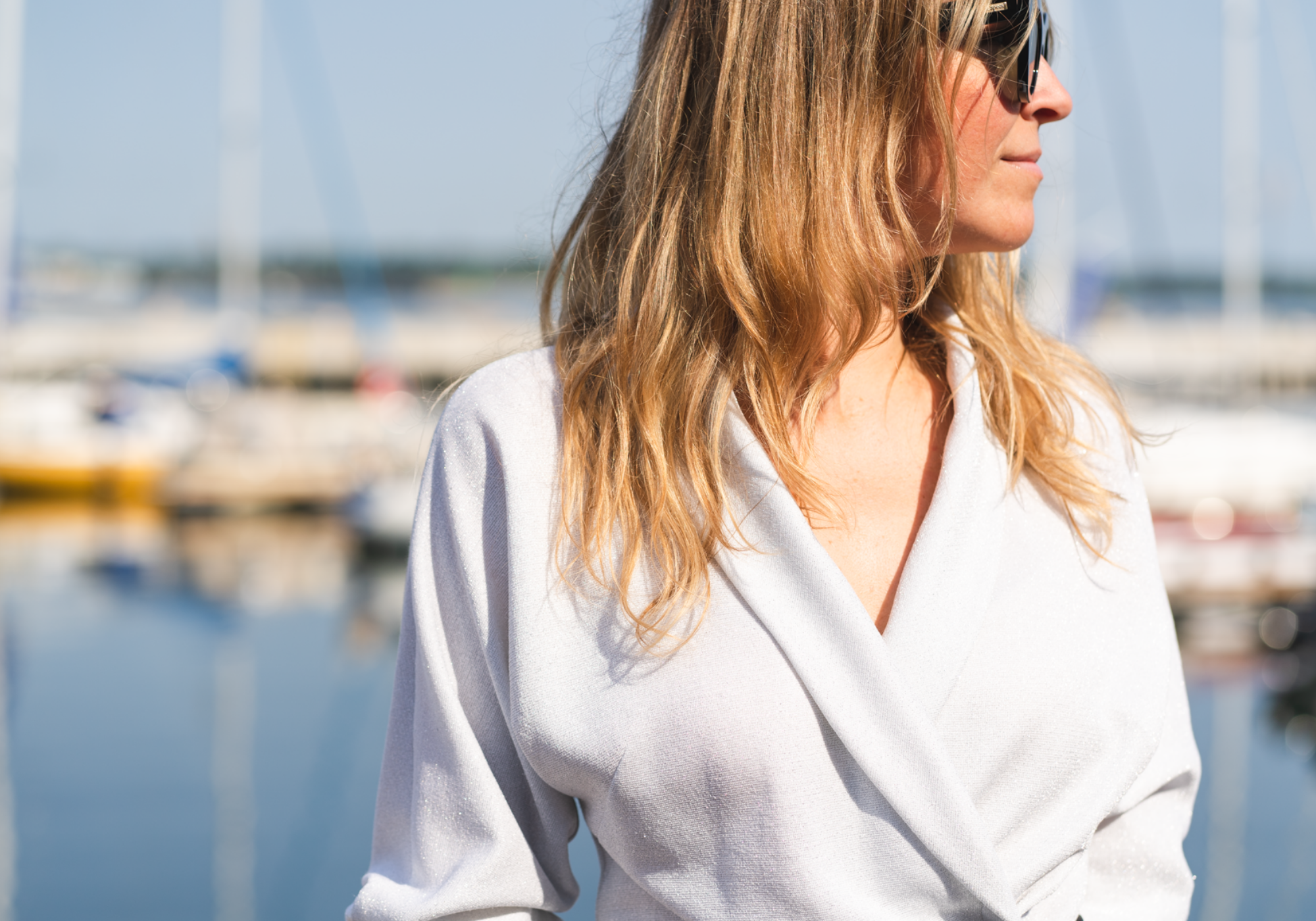 woman wearing a wrap blouse is a yacht harbour