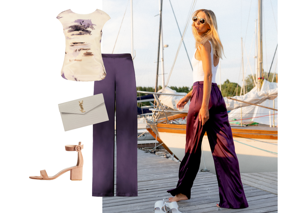 woman wearing silk wide leg pants and a bodysuit in a yacht harbour