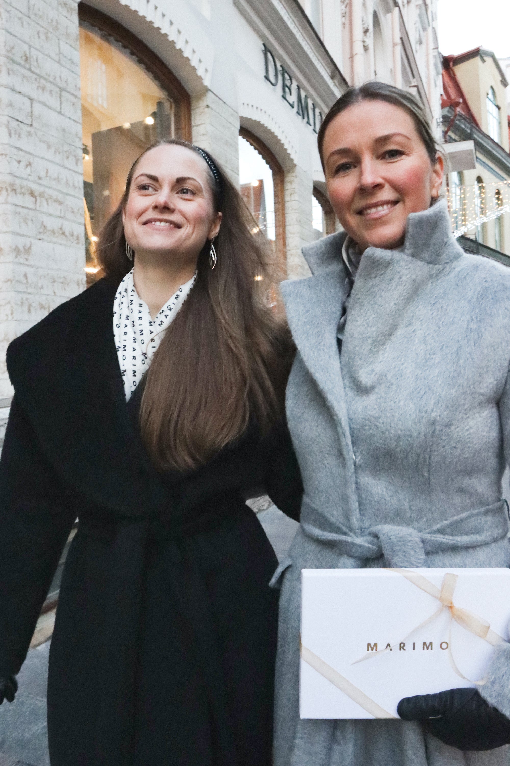 Two elegant women wearing quality coats
