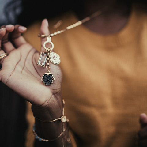 Woman Holding AIR AND ANCHOR necklace with Crystal Charm.