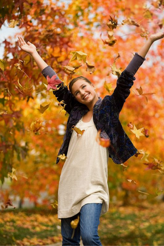 girl throwing leaves in the air
