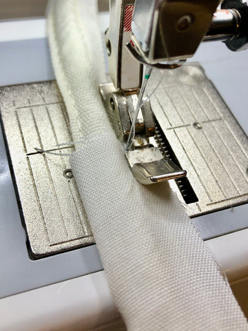 Zipper foot sewing the fabric onto the boning.