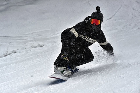 A snowboarder surfing on snow.