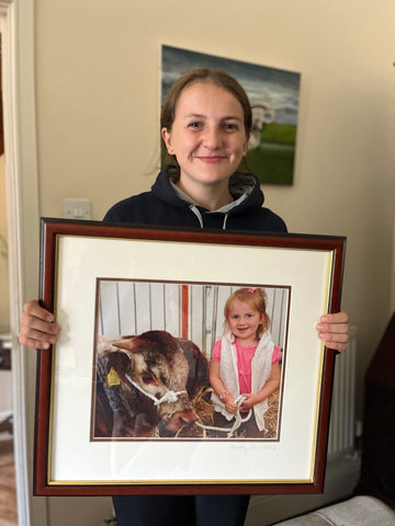 jess holding photo of herself and long horn cattle rosette