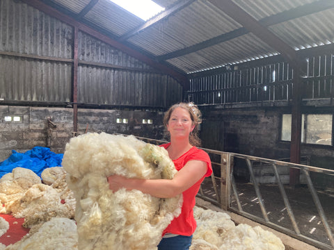 Kate with arms full of fleece looking. happy