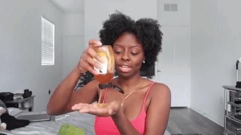 woman applying leave-in conditioner on natural hair