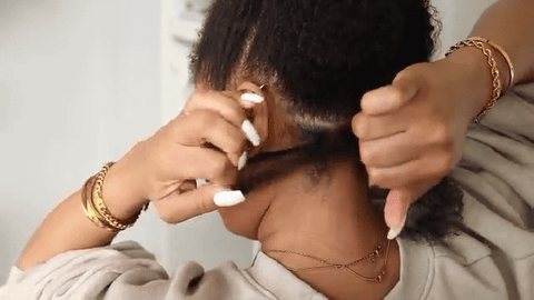 woman tying natural hair with rubber band