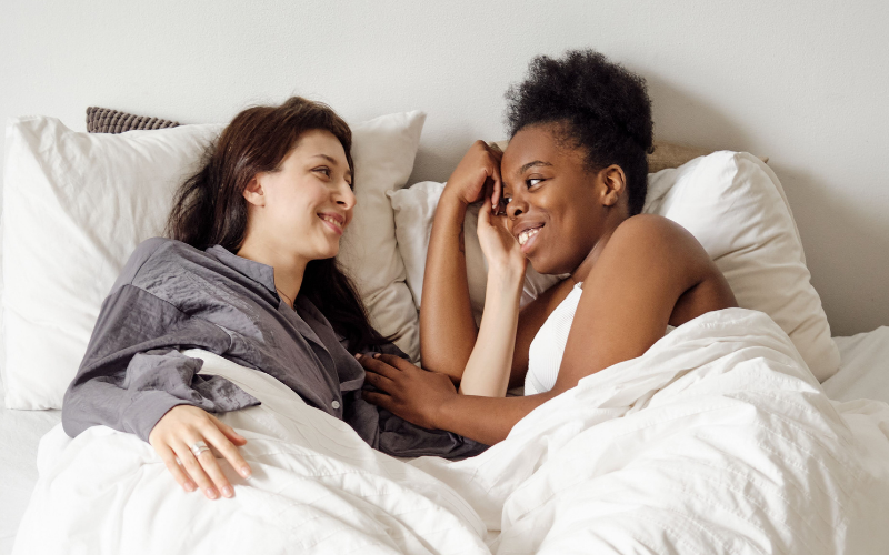 Image of a lesbian couple in bed together