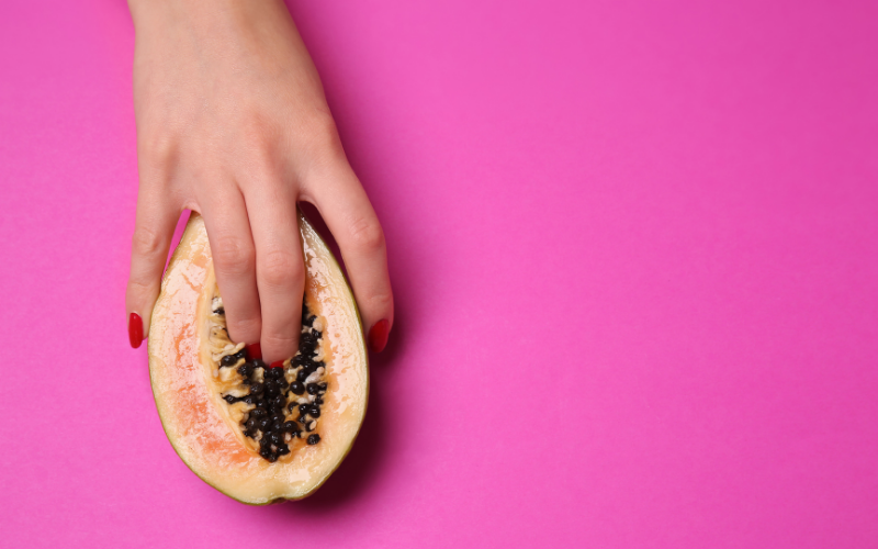 Image of fingers in cut open fruit