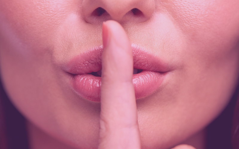 Women with finger pressed against lips