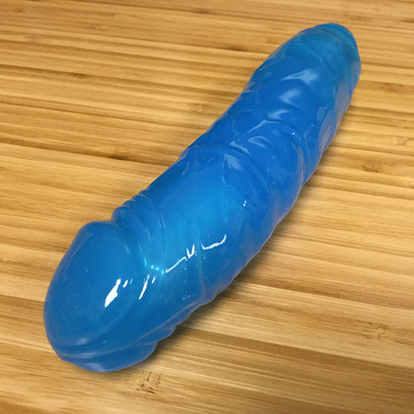 Blue Vibrator Laid On Desk Showing The Veins And Realistic Attributes Of The Toy