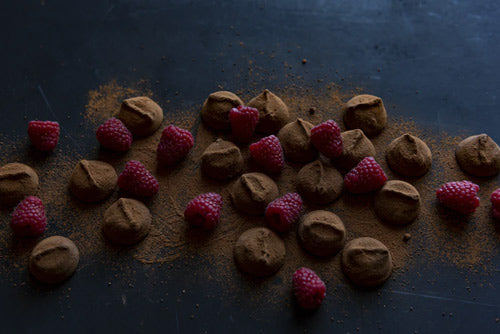 a spread of chocolate truffles and raspberries