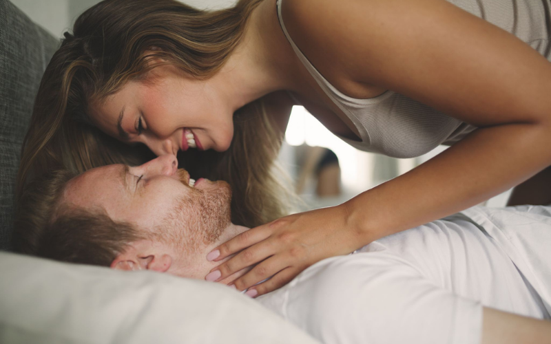 Man and woman smiling in bed together