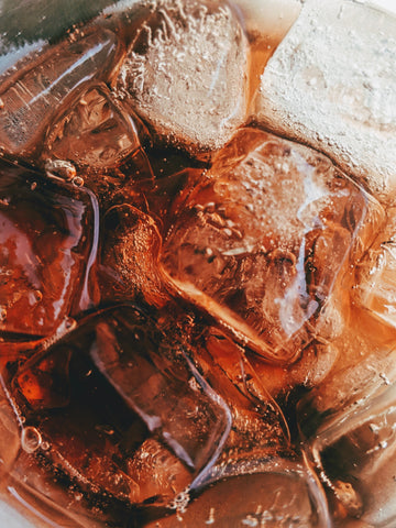 Photo of dark bubbly liquid with ice by Photo by Photo Credit: Photo by Vinicius "amnx" Amano on Unsplash