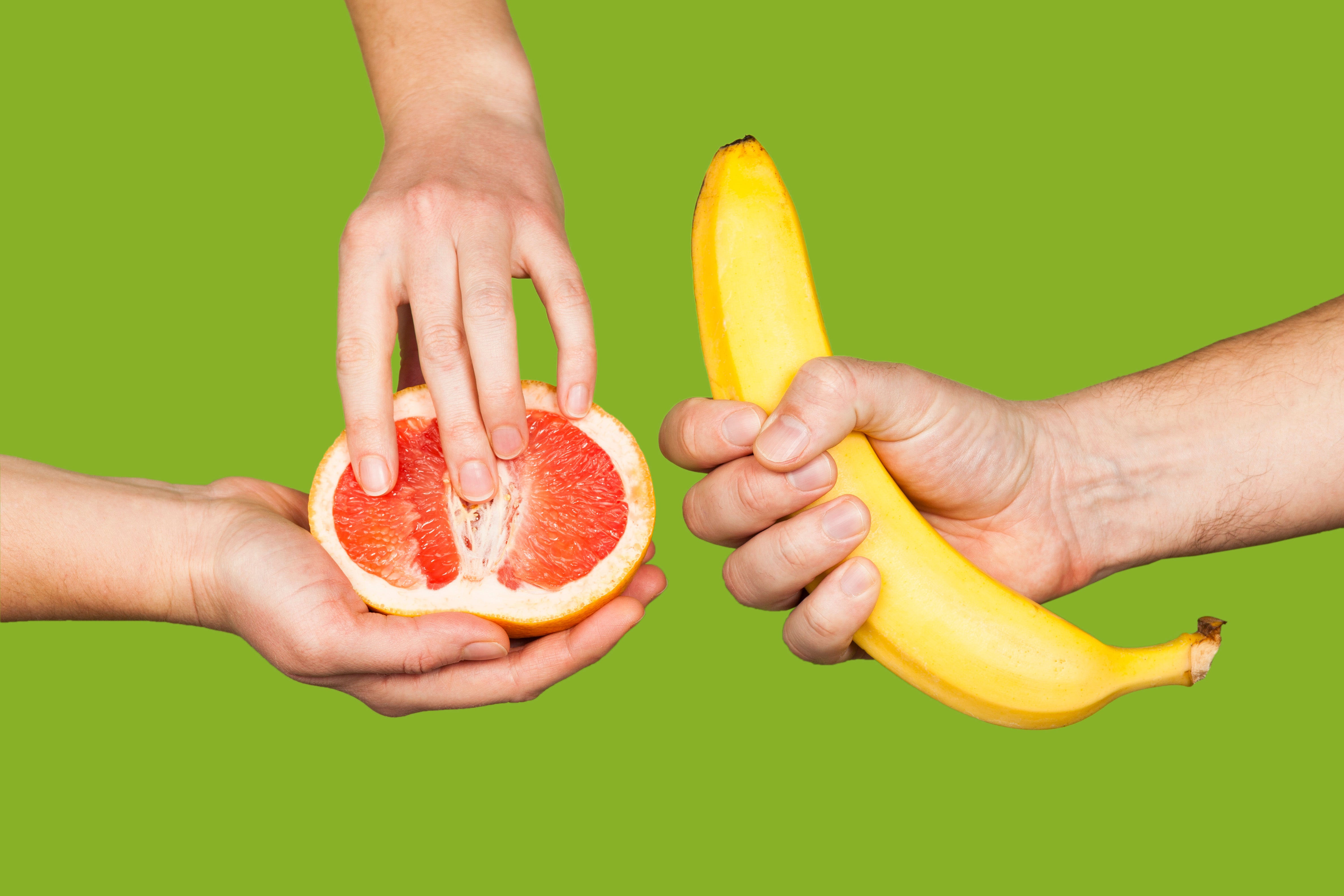 One hand holding a banana with a tight grip, another hand holding a slice grapefruit. As if to imitate a handjob and fingering a woman.