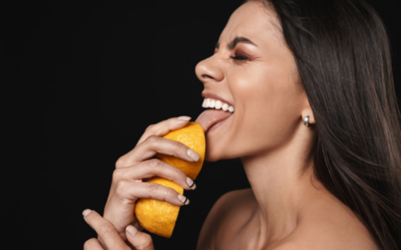 Image of woman licking a fruit