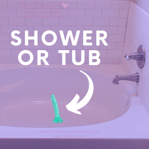 Image of a green dildo on the floor of a bathtub showing how you can use a suction cup dildo in the shower or tub