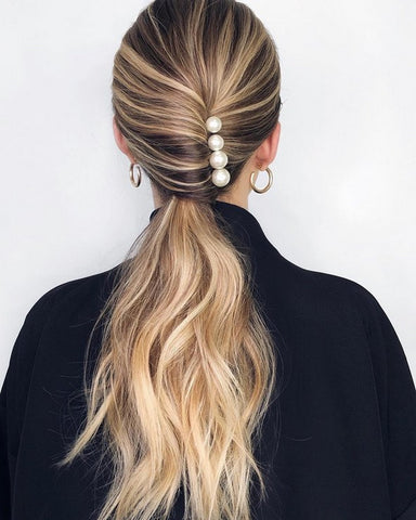 long blonde low ponytail with a pearl barrette