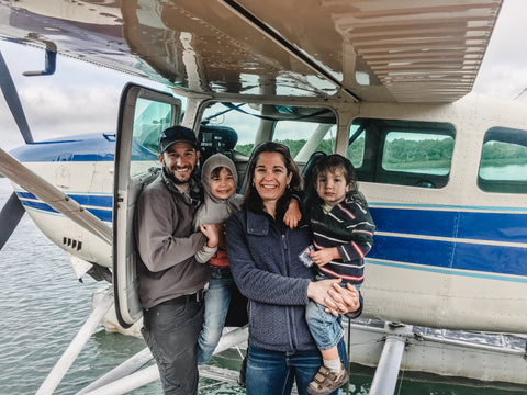 Steve and Jenn Kurian with their children, Ava and Tommy, standing in front of a float plane in Bristol Bay Alaska