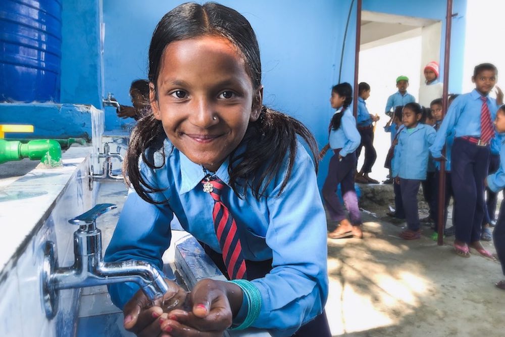 Child in a school washing her hands