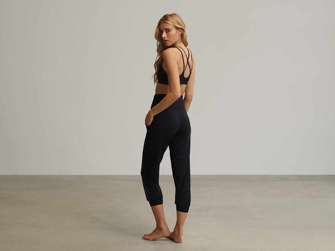 Girl looking over her shoulder wearing the Butter Yoga Bra and Butter High Rise Cropped Jogger