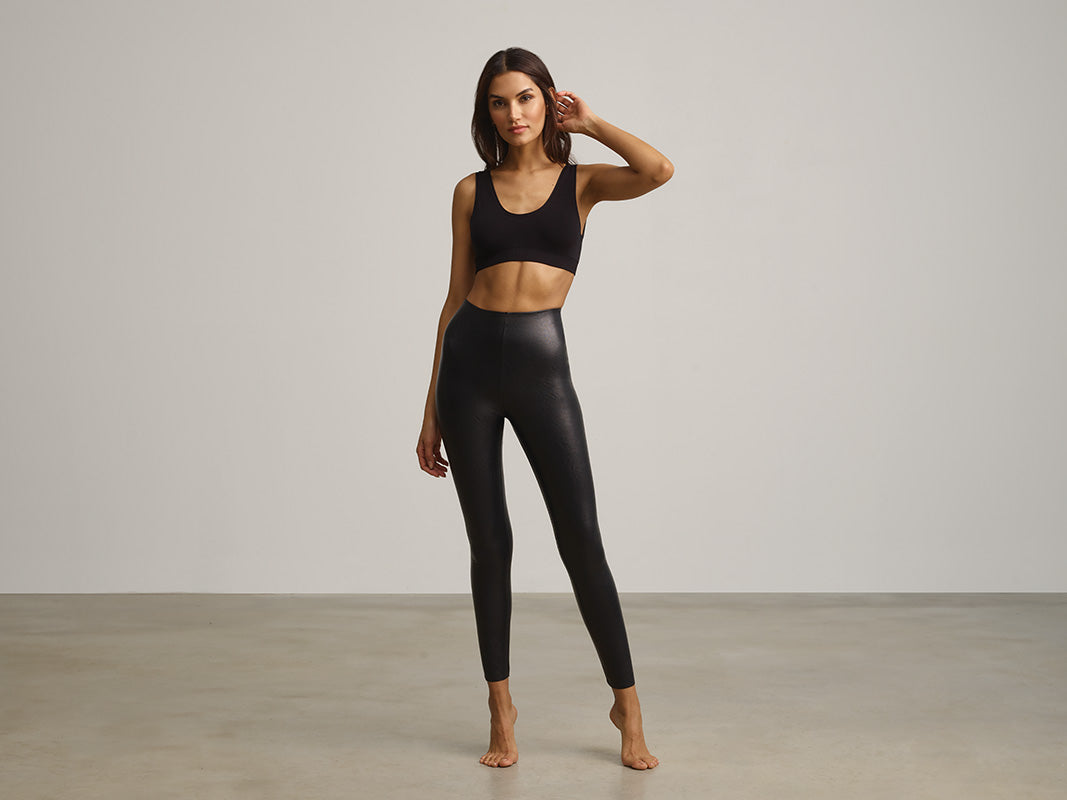 Woman posing in black Minimalist Tank Bra and black Faux Leather Leggings