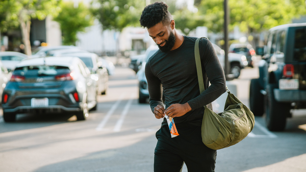 Man opening PROTEIN bar on the way to the gym