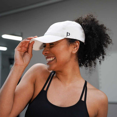 White Ponyback Sporty Fit Ponytail Hat on confident woman smiling