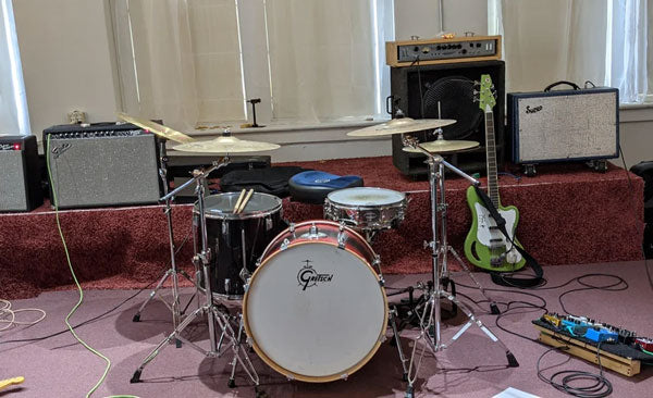 drum kit set up in the middle of a recording room