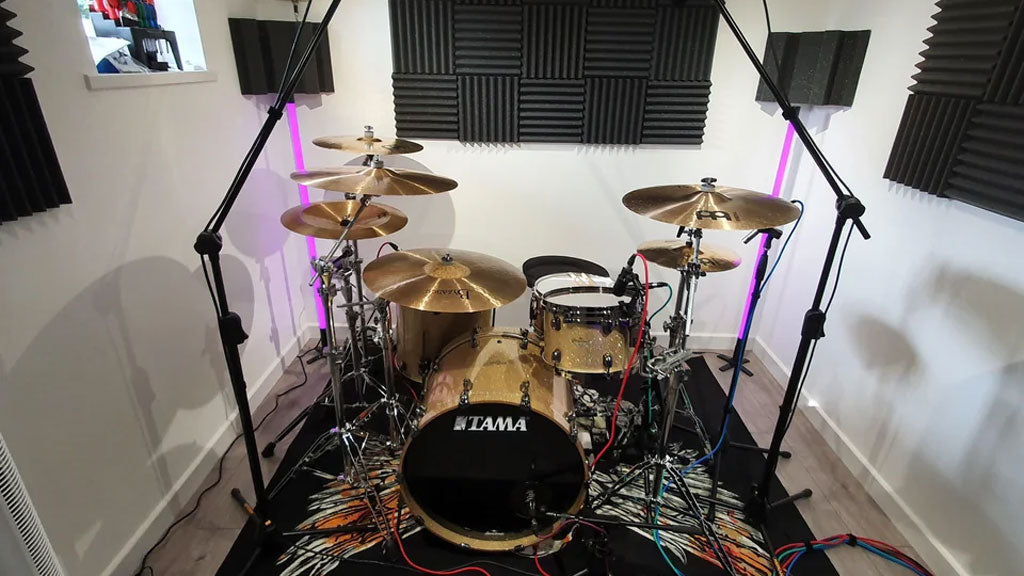 drum kit set up with microphones at a home studio