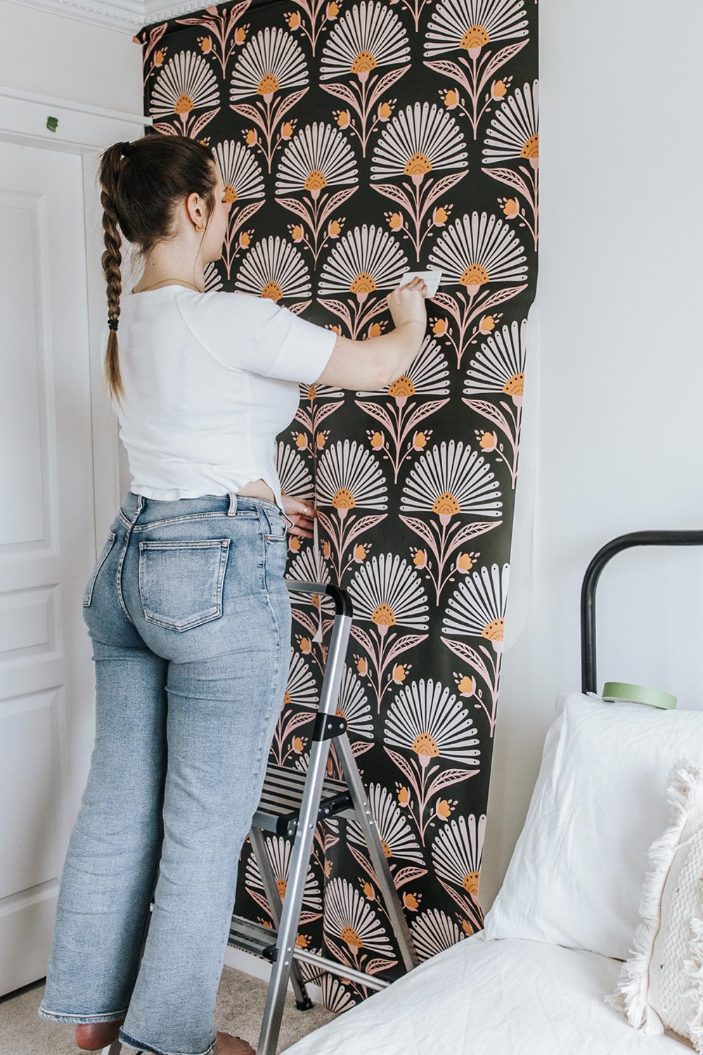 Halli installing Flourish Wallpaper in bedroom.