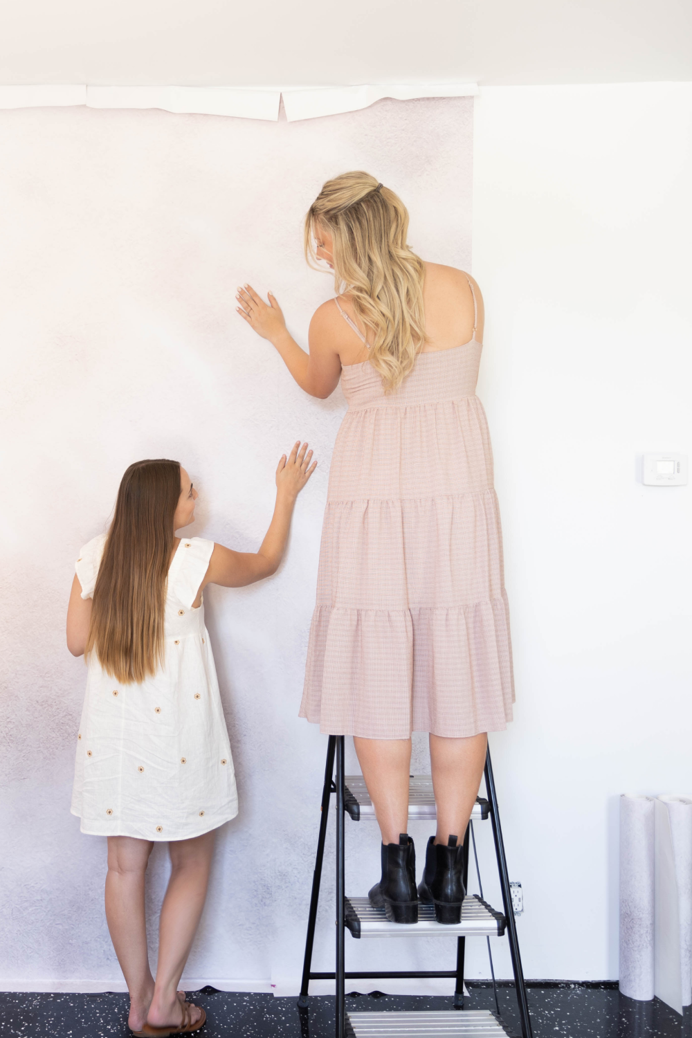 women installing urbanwalls wall mural