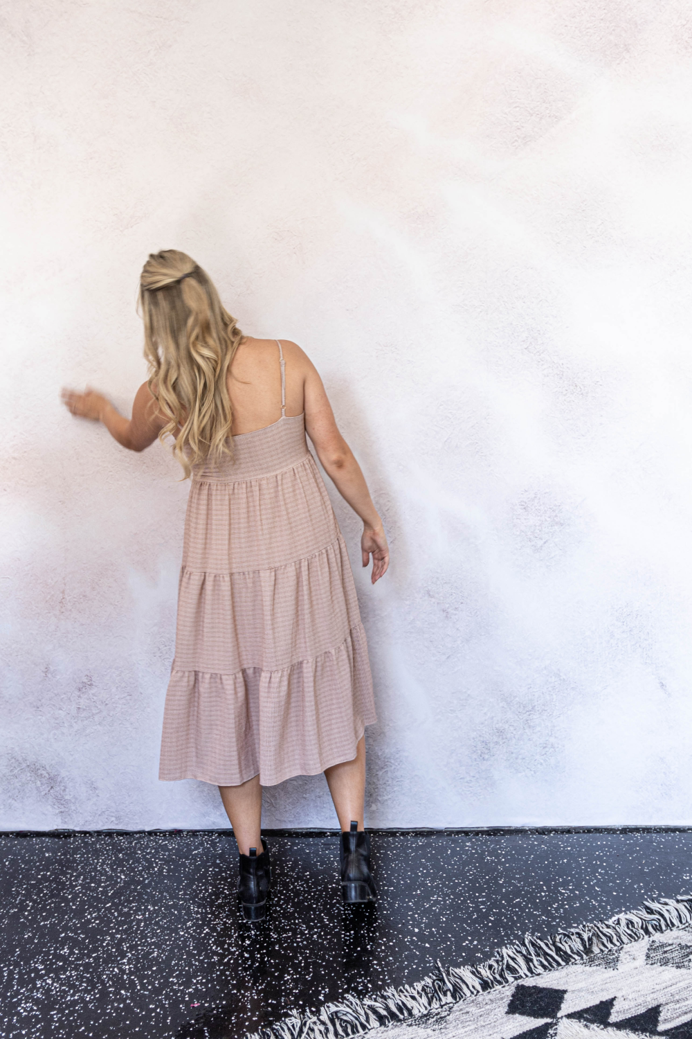 woman standing in front of radial tie-dye wall mural