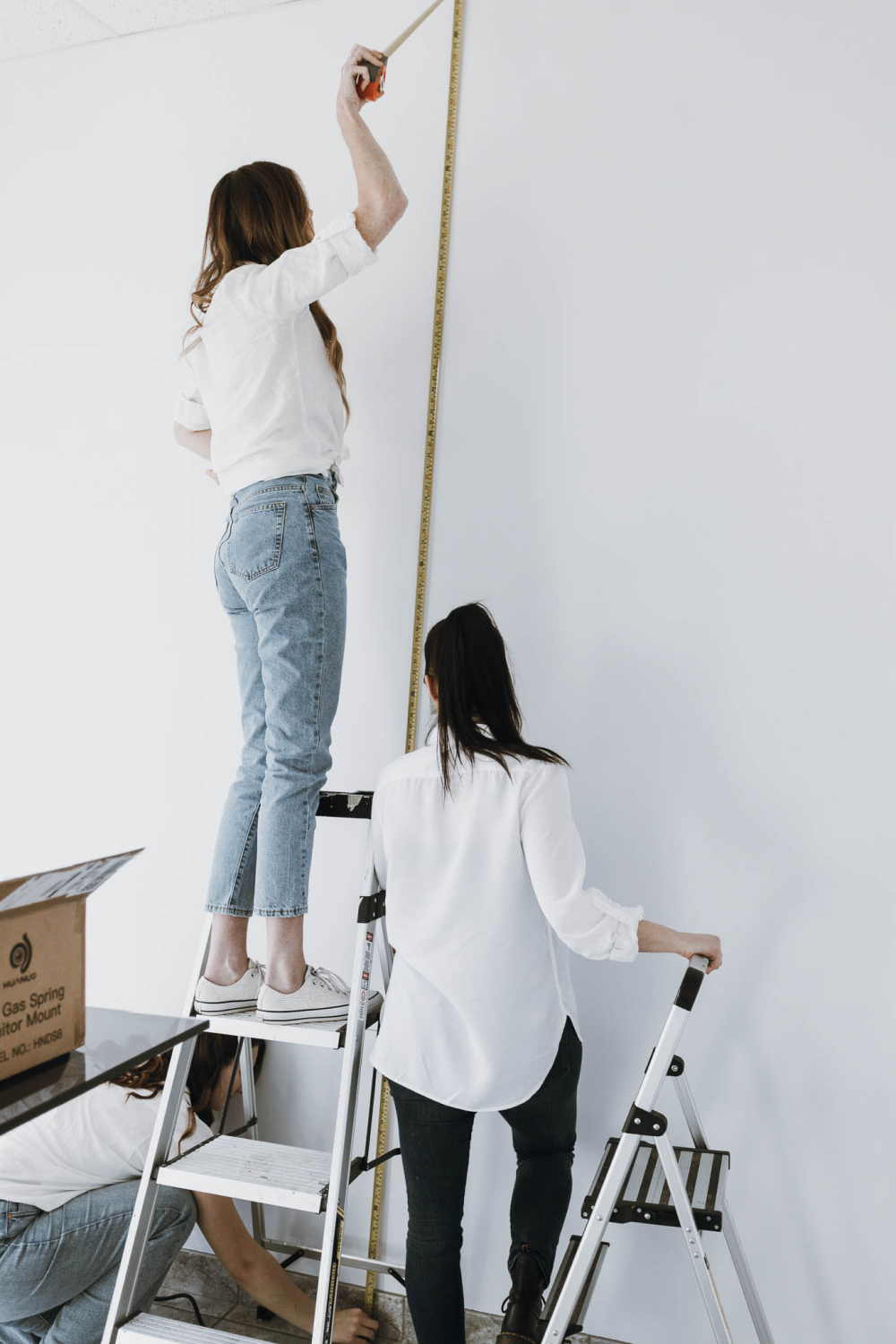 women measuring wall